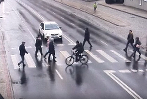 Screen z nagrania z monitoringu. Piesi i rowerzysta przechodzą przez przejście.