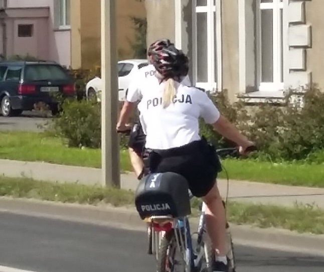 Dwaj policjanci jadą na rowerach - policyjny patrol rowerowy na ulicach Bartoszyc