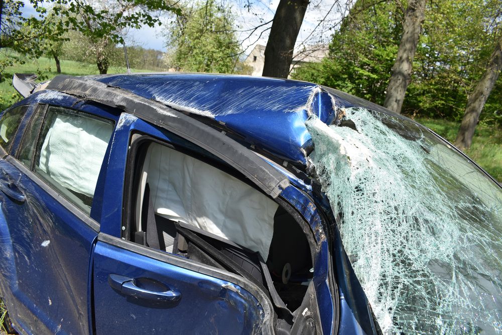 Miejsce zdarzenia drogowego w powiecie nowomiejskim, rozbity samochód na drodze