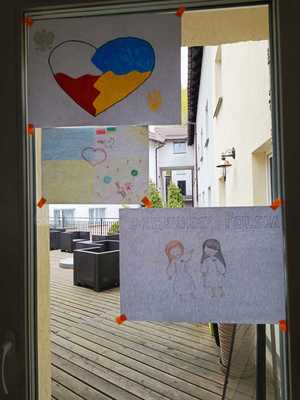 Rysunki przygotowane przez ukraińskie dzieci i powieszone na szklanych drzwiach.