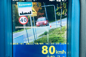 Zdjęcie wykonane ręcznym miernikiem prędkości, na którym widać jadący drogą samochód
