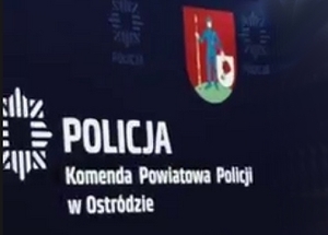 Napis Komenda Powiatowa Policji w Ostródzie na niebieskim tle