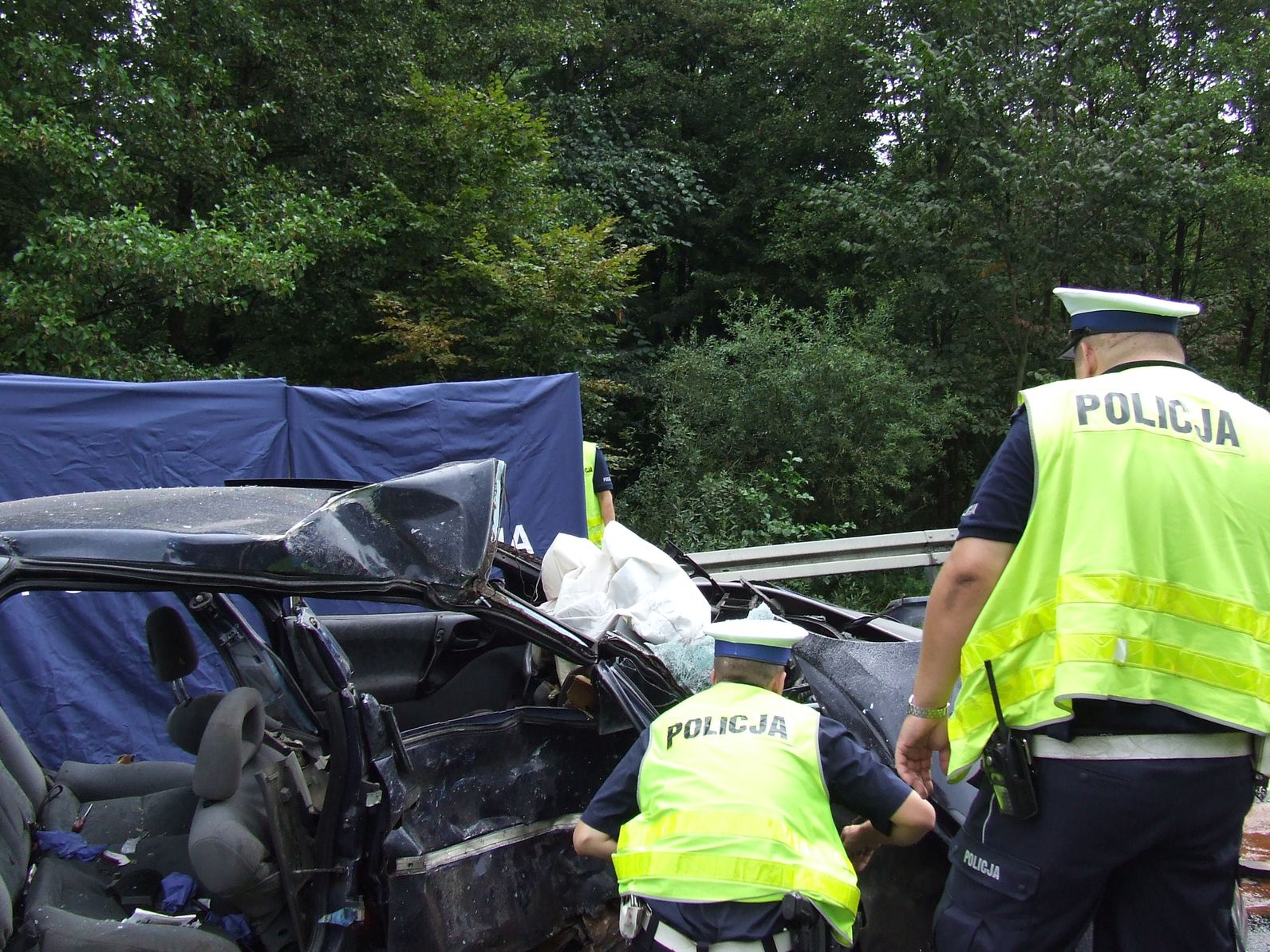Policjanci pracujacy na miejscu wypadku drogowego