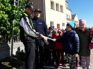 Dzielnicowy z przedszkolakami rozdają odblaski