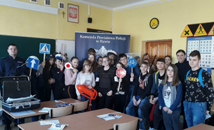 Młodzież w klasie pozuje do zdjęcia z policjantami