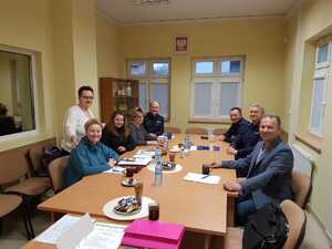 Mieszkańcy siedzący przy stole podczas spotkania z dzielnicowymi