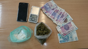Zabezpieczone pieniądze - kilkanaście banknotów o nominałach 10, 20, 50 złotych, telefon komórkowy oraz woreczek foliowy z zawartością białego proszku oraz woreczek foliowy z zawartością roślinnego suszu