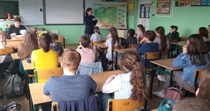 Policjantka rozmawia z uczniami na temat bezpieczeństwa.