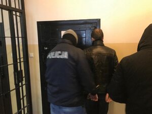 Zatrzymany mężczyzna prowadzony przez policjanta