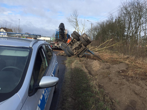 Miejsce zdarzenia drogowego w powiecie szczycieńskim. Radiowóz stojący na jezdni i uszkodzona ciężarówka