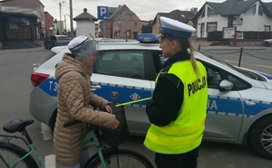 Działania Jednoślad - policjantka ruchu drogowego wręcza odblask rowerzystce