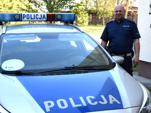 mł. asp. Jarosław Niegowski przy radiowozie