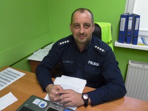 asp. szt. Arkadiusz Tobisz siedzący przy biurku