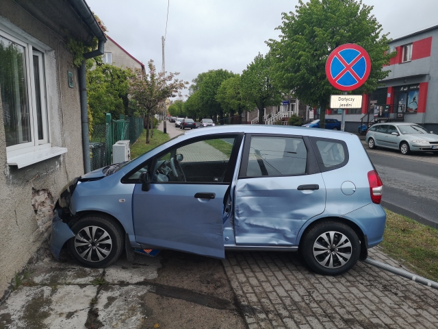 Auto marki Honda, po zderzeniu ze ścianą budynku. Widoczny bok samochodu z wyraźnymi uszkodzeniami