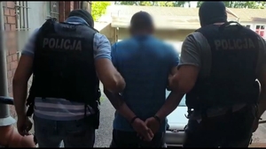 policjanci doprowadzają zatrzymanego mężczyznę