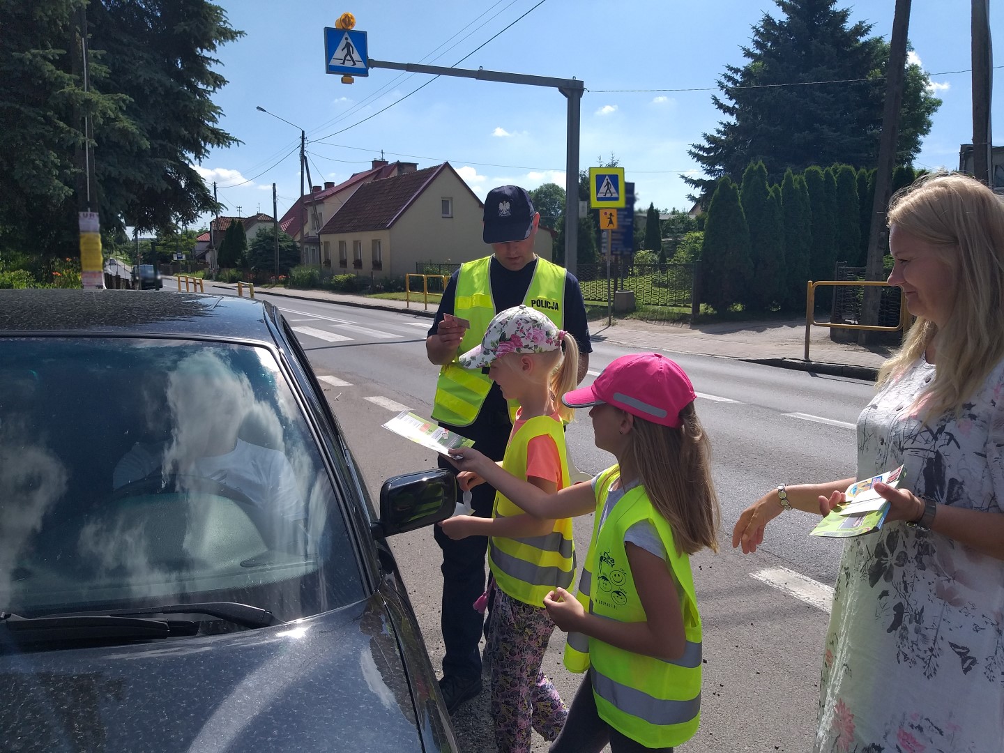 Dzieci i policjant podczas kontroli drogowej