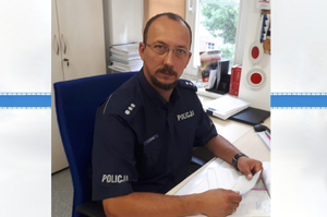 kom. Arkadiusz Wróbel siedzący za biurkiem