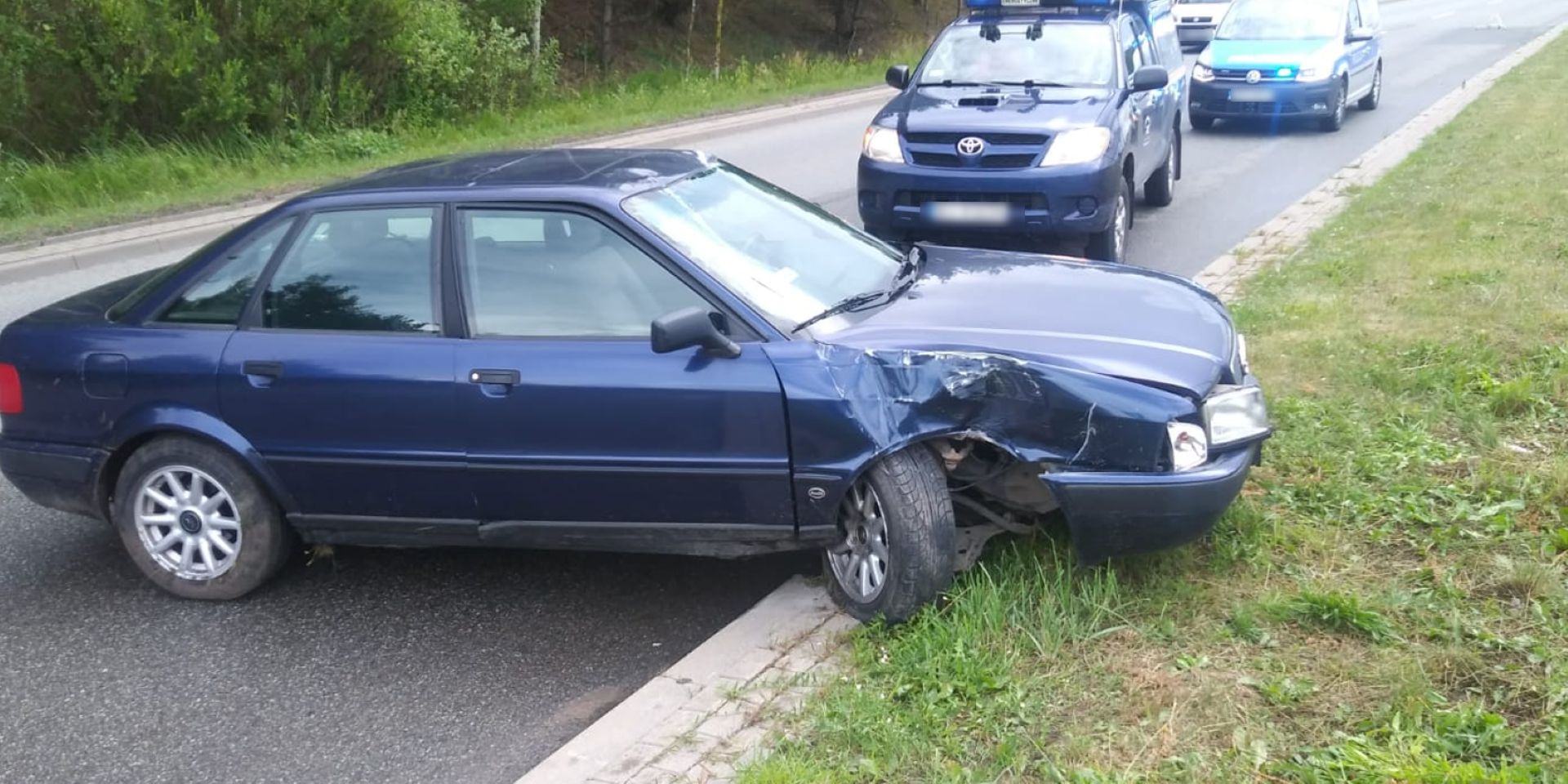 Miejsce zdarzenia drogowego w Ełku, uszkodzony samochód na drodze