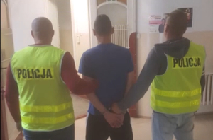 Jeden z zatrzymanych mężczyzn trzymany przez policjantów