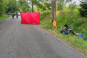 Miejsce zdarzenia drogowego w powiecie giżyckim. Rozbity motocykl leżący na poboczu