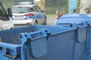 Ugaszony kontener i radiowóz w tle