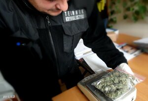 Policjant trzyma zabezpieczone narkotyki