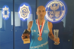 Andrzej Mankow z medalem i statuetkami