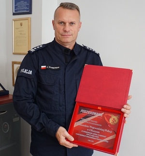 I Zastępca Komendanta Wojewódzkiego Policji w Olsztynie trzymający w rękach tablicę pamiątkową