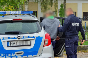 Zatrzymany mężczyzna prowadzony przez policjanta