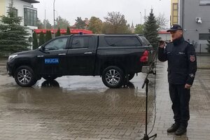 insp. Jan Markowski przed mikrofonem, w tle nowa Toyota Hilux