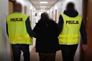Zatrzymany mężczyzna prowadzony przez policjantów