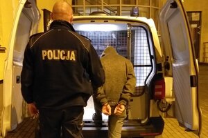 Zatrzymany mężczyzna prowadzony przez policjanta