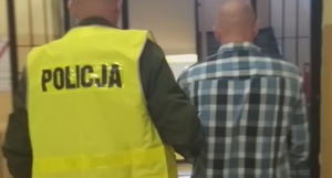 Zatrzymany mężczyzna prowadzony przez policjanta