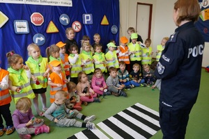 Policjanci i dzieci biorące udział w odblaskowym pokazie mody