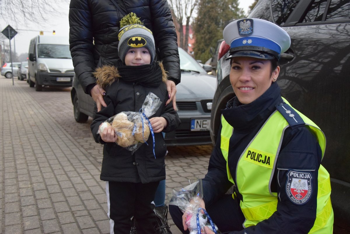 Policjantka z dzieckiem, które trzyma w ręku misia