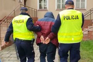 Zatrzymany mężczyzna prowadzony przez policjantów