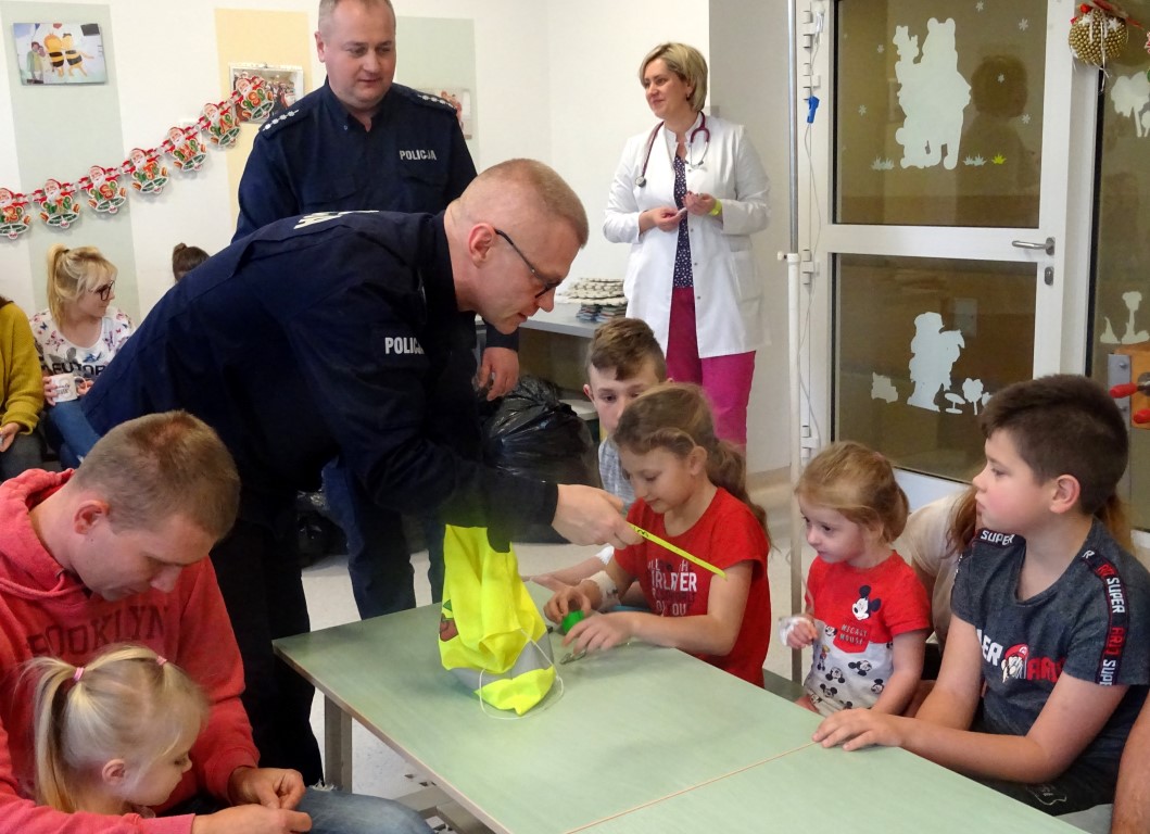 Policjanci podczas spotkania z dziećmi rozdają zabawki