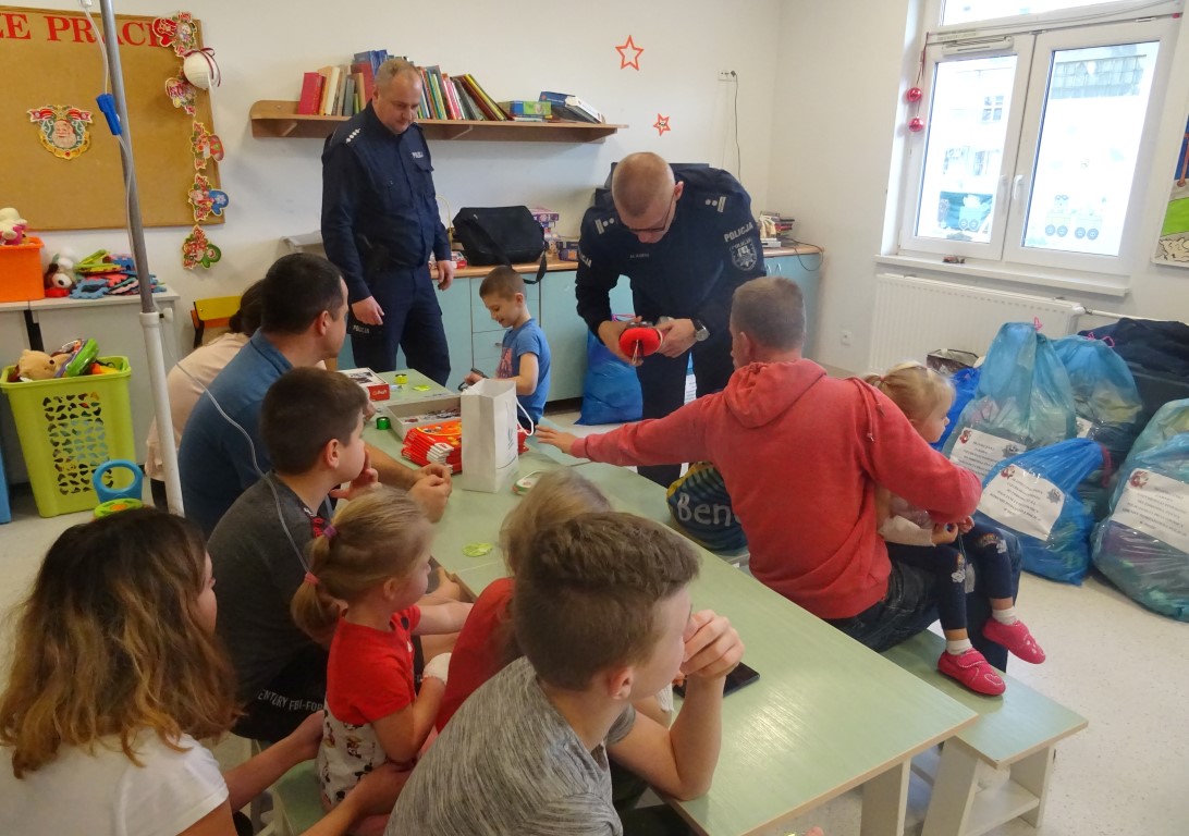 Policjanci podczas spotkania z dziećmi rozdają zabawki