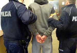 Zatrzymany mężczyzna prowadzony przez policjantów
