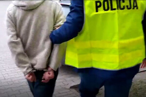 Zatrzymany mężczyzna prowadzony przez policjanta