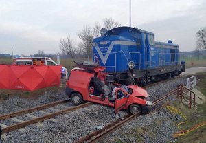 Uszkodzony pojazd osobowy po zderzeniu z pociągiem na przejeździe kolejowym