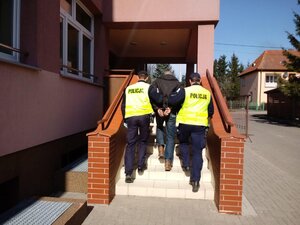 zatrzymany mężczyzna prowadzony przez policjantów