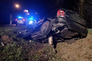 Rozbity samochód w przydrożnym rowie i radiowóz w tle