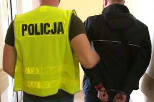 Zatrzymany mężczyzna prowadzony przez policjanta