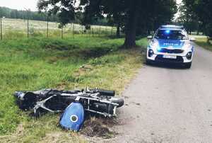 Miejsce wypadku motocyklisty w Kołodziejowym Grądzie. Motocykl na poboczu, radiowóz na drodze.