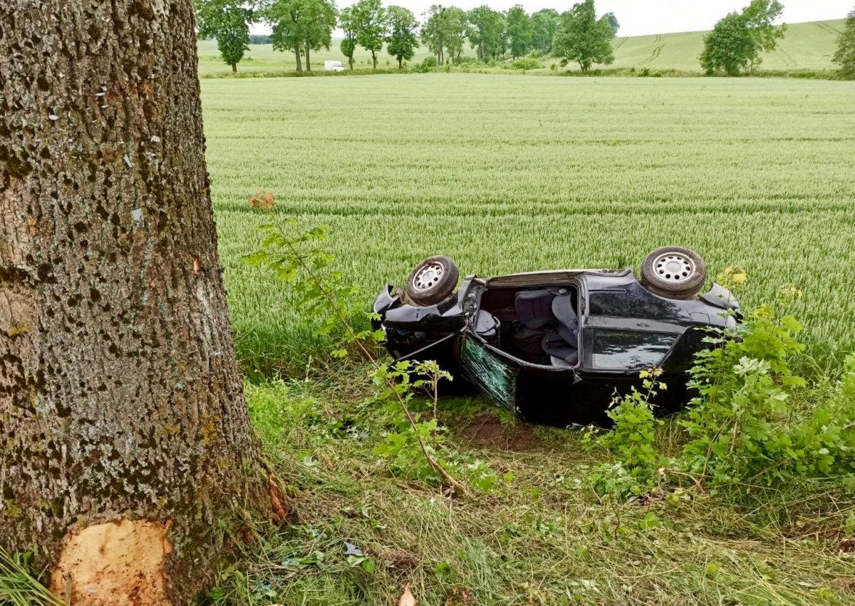 zniszczony samochód leżący w polu