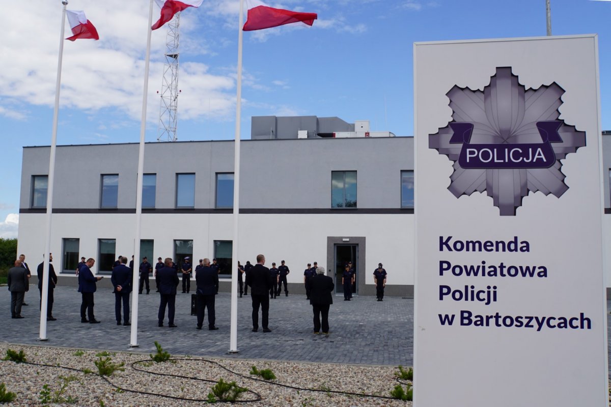 Policjanci i zaproszeni goście przed budynkiem KPP w Bartoszycach