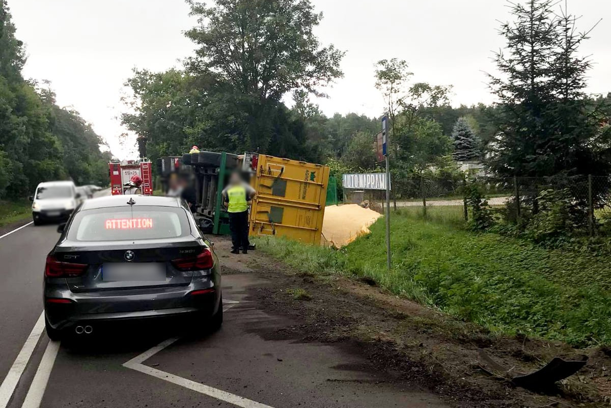 Miejsce zdarzenia drogowego w powiecie szczycieńskim. Radiowóz i ciężarówka przewrócona na drodze