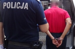 Zatrzymany mężczyzna prowadzony przez policjanta