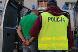 Zatrzymany mężczyzna prowadzony przez policjanta
